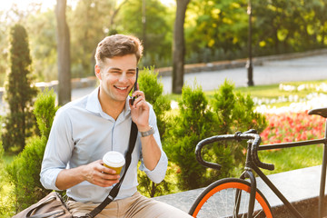 Happy young stylish man talking on mobile phone