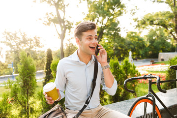 Cheerful young stylish man talking on mobile phone
