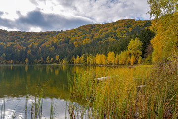 Autumn landscape. Saint Ana lake in Romania, the only volcanic lake in Europe, formed in a crater of a dead volcano