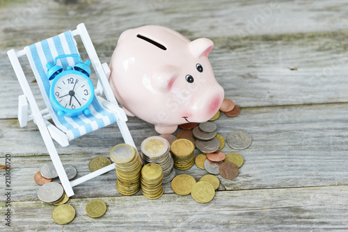 Old Fashioned Alarm Clock On Beach Chair Near Piggy Bank And Cash Old Fashioned Alarm Clock On Beach Chair Near Piggy Bank And Cash Money Suggesting Time