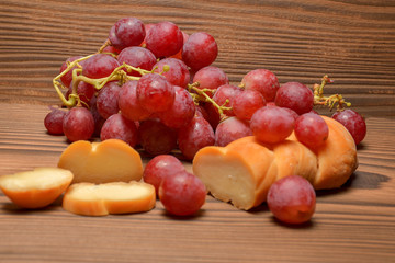 cheese and grapes on wooden background with copy space, selective focus.