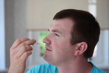 A man putting a nasal spray in nose.

