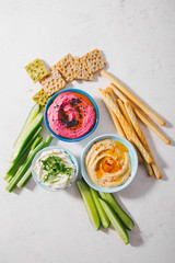 Fresh vegetarian dips in small bowls on table