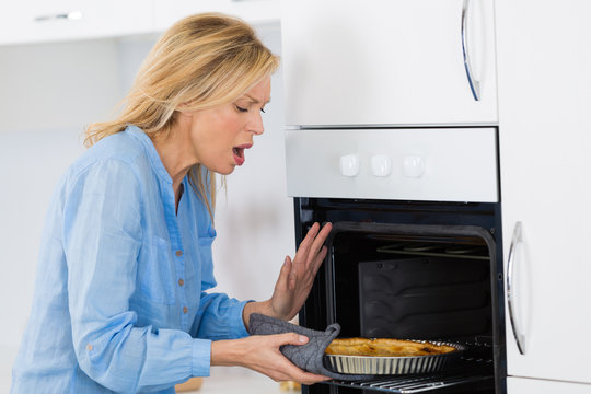 woman burn hand while getting a tart off the oven
