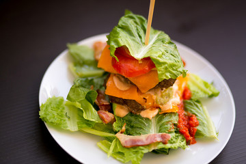 Burger salad with fresh lettuce leaves, tomato, chop and cheese