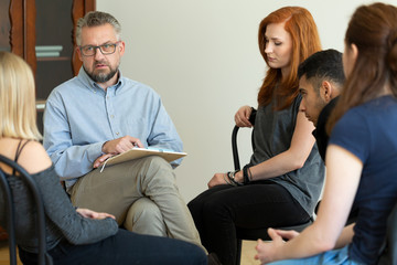 Serious teacher talking to a group of rebellious teenagers in school detention