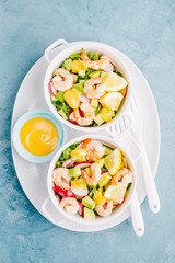Salad with prawns in bowls on table