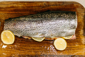 raw fish. raw fresh salmon, trout, on a table on a cutting board. with lemon ready for baking