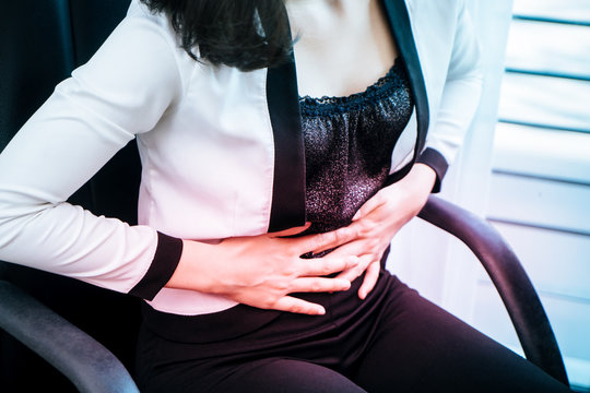 Woman in office is hacing painful stomach ache