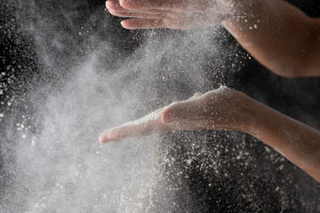 Fototapeta na wymiar hands with flour on a black background