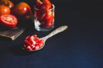 Fresh red tomato in wooden spoon healthy food and vegetable concept on black background