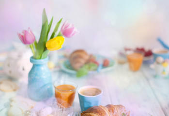 Easter breakfast flat lay with, bread toast with fried egg and gre, colored quail eggs and spring holidays decorations. Top view. Copy space. croissants for breakfast. Free space for text or postcard.