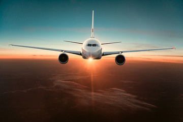 Fototapeta premium Samolot komercyjny lecący nad dramatycznymi chmurami.