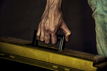 brutal textured hand of the Builder holding the tool box - obrazy, fototapety, plakaty