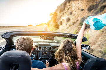 Couple on convertible car - obrazy, fototapety, plakaty