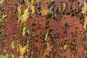 Rusty iron sheet with flaky paint in crumpled light