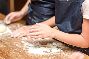 Obraz na płótnie Canvas Close-up of children's hands preparing dough for pizza