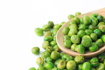 green peas on plate and wooden