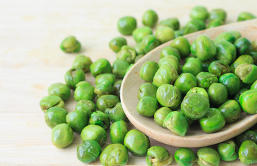 green peas on plate and wooden