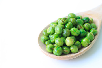 green peas on plate and wooden