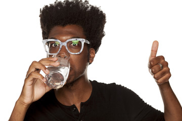 Portrait of young african american man drinking water from a glass  on white background - Powered by Adobe