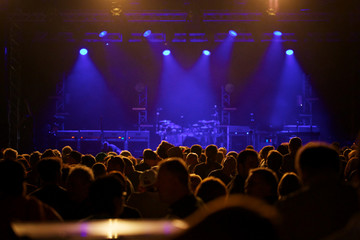 Fototapeta na wymiar Empty concert stage with crowd in front blue stage lights