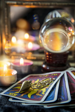 Tarot cards, crystal orb, pendulum, candellight  and a mirror, magic night scene