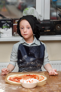 Pizza, children and the concept of cooking - children make pizza. Preparation of pizza, a master class for children and a fuzzy focus on ingredients for pizza.