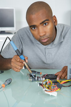 Portrait of man using soldering iron