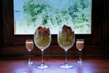 fruity cocktail with ice cream, alcohol against a window with a landscape