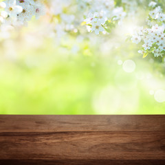 Naklejka na ściany i meble Cherry blossoms in park with wooden table
