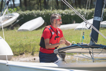 Fototapeta premium portrait of mature sportsman near catamaran