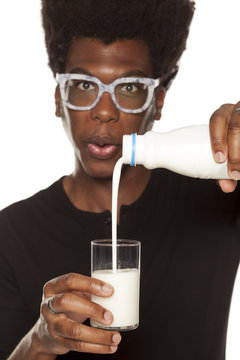 Portrait of young african american man drinking water from a glass  on white background