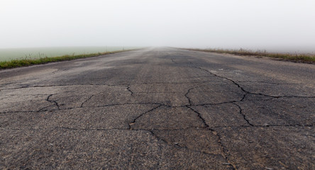 Asphalt road into the fog