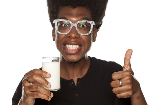 Portrait of young african american man drinking yogurt from a glass on white background