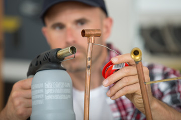 Tradesman soldering with blow torch