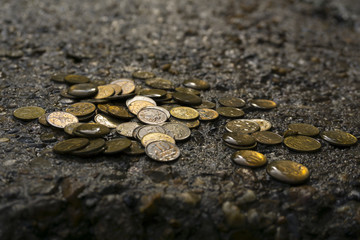 Perm, Russia - July 12, 2018: discarded wet coins on the concrete in the open air in gloomy tones