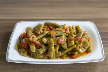 olive oil green beans in the white plate on the wooden table for restaurant or kitchen concept.