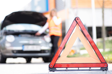 Junge Frau hat eine Panne mit ihrem Auto