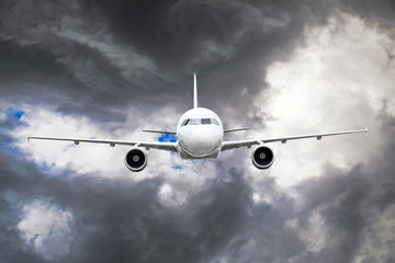 Passenger airplane flies through the turbulence zone through the lightning of storm clouds in bad weather.