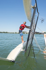 Fototapeta premium salior trying to right his catamaran after capsize