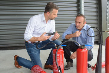 Men examining fire extinguishers