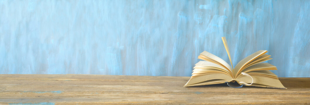 opened book on blue grungy background, panoramic, good copy space