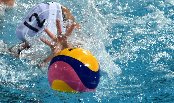 Hand try to reach the waterpolo ball in the swimming pool.