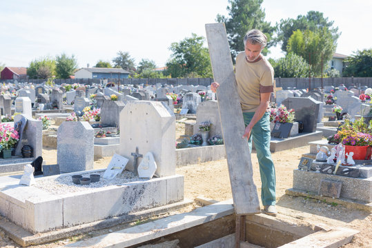 man looking after at the grave in the cemetery