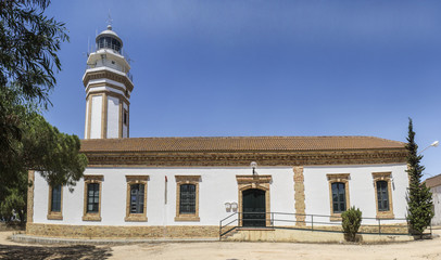 Fototapeta na wymiar Urban lighthouse building at Mazagon, Costa de la Luz, Huelva