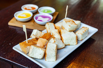 Colourful Steamed Custard and Milk with steamed bread in the White Plate on Wood Table.