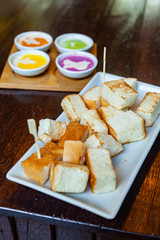Colourful Steamed Custard and Milk with steamed bread in the White Plate on Wood Table.