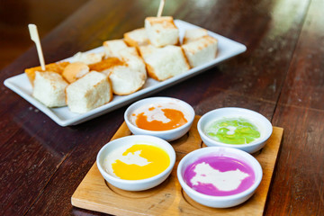 Colourful Steamed Custard and Milk with steamed bread in the White Plate on Wood Table.