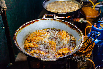 Chicken Deep Frying in Oil on Big Iron Pan Street Food.